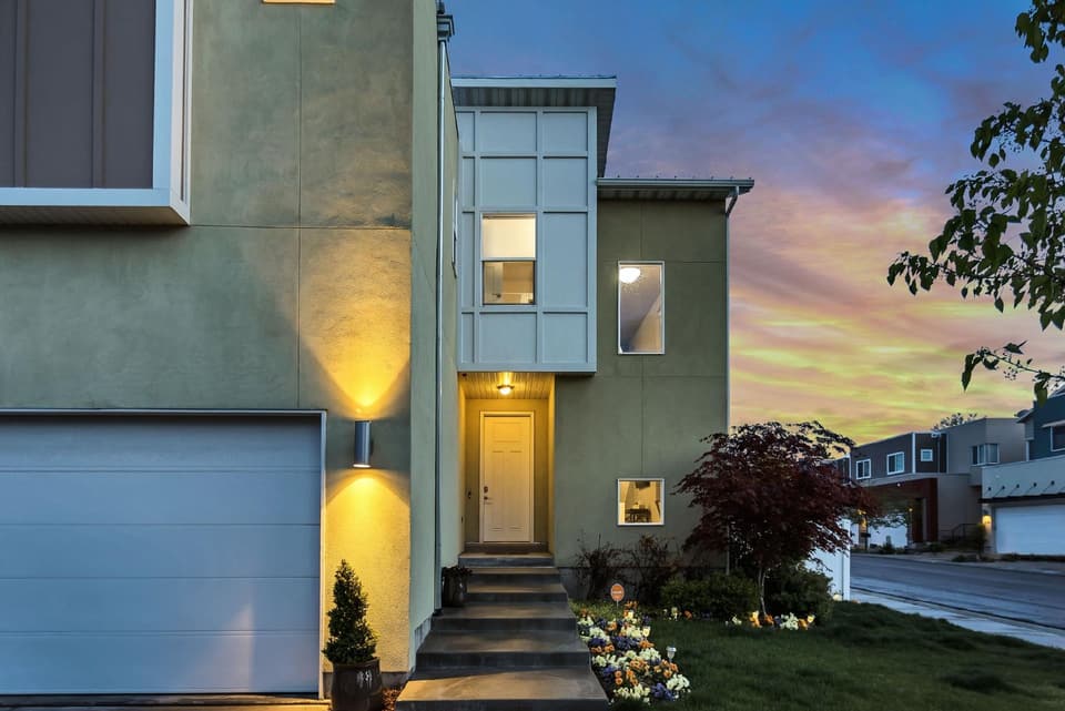 Modern townhome entrance lit at dusk